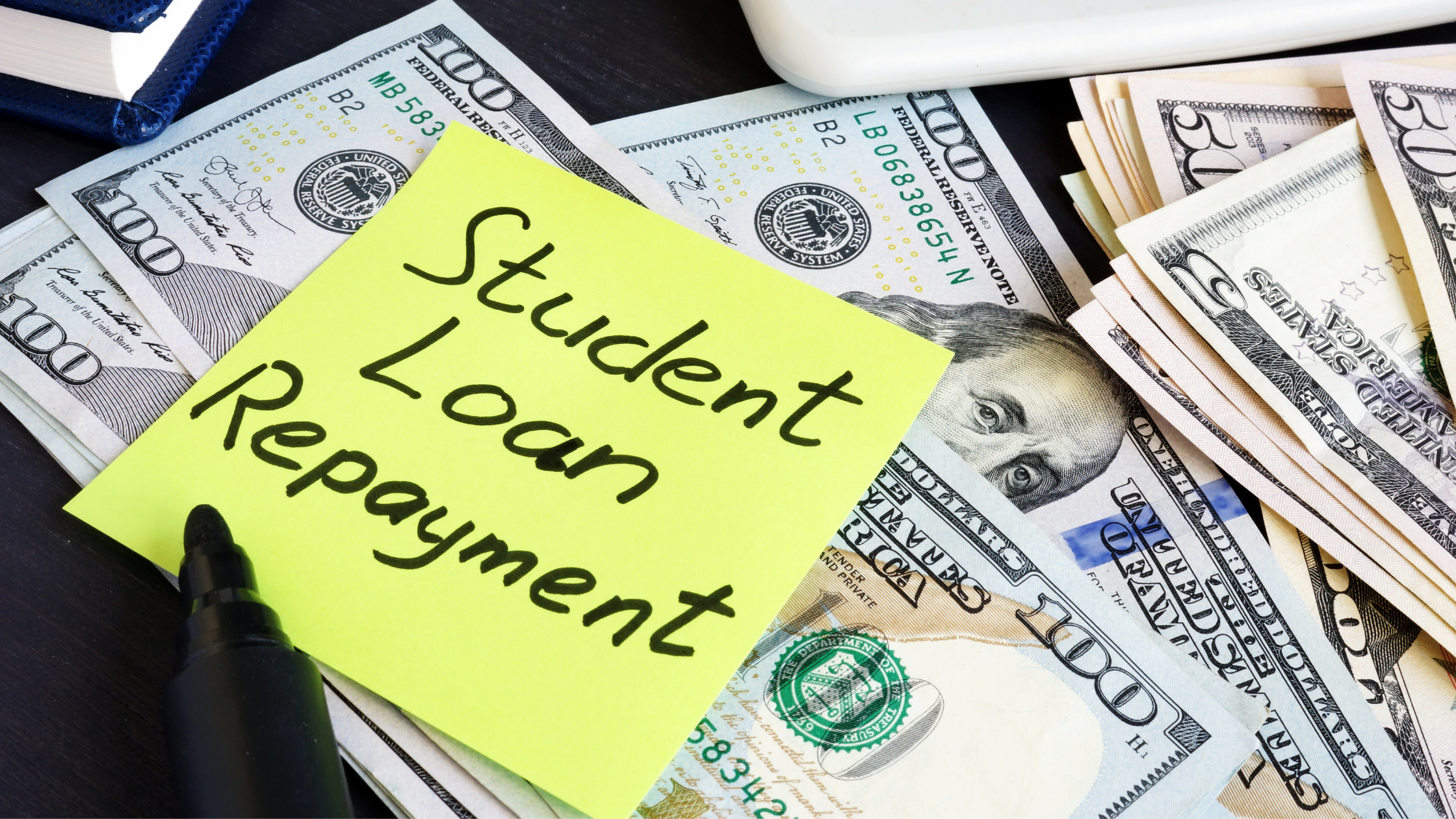 Student loan income-driven repayment plan sticky note on top of hundred dollar bills, representing financial management options for student debt.